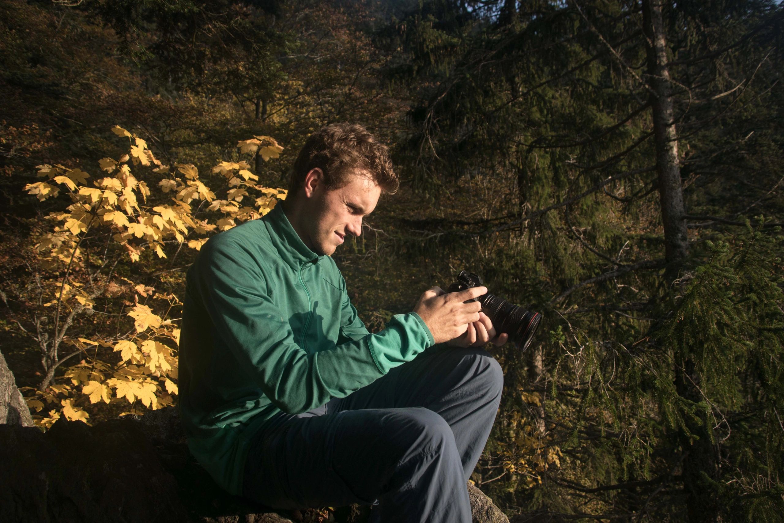 Young photographer holding a camera outdoors.